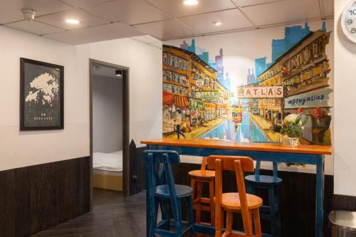 a bar in a restaurant with a mural on the wall at Atlas Hostel & Backpackers in Hong Kong