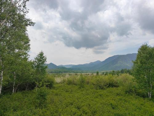 a view of a field with mountains in the background at 4BR Entire House near Nikko & Highway EV Parking in Nikko