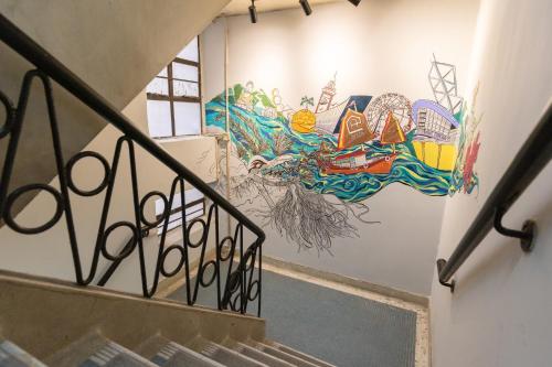a staircase with a mural on the wall at Atlas Hostel & Backpackers in Hong Kong