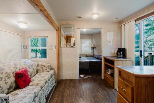 a living room with a couch and a kitchen in a room at 2-bedroom Camper Trailer Cottage #1 in Dillon
