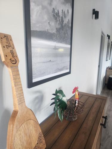 a wooden guitar sitting next to a table with a plant at Pool Villa No 10 in Vaimaanga