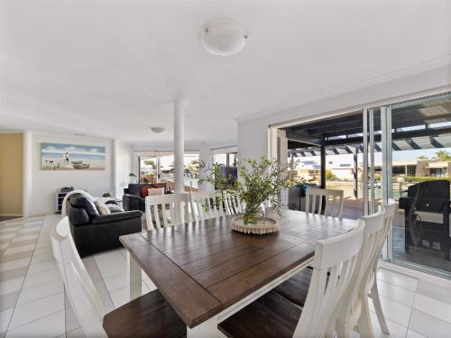 a dining room and living room with a table and chairs at Private Jetty -family & Pet Friendly in Mandurah