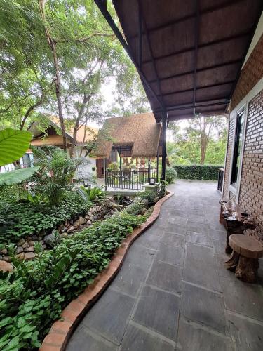 a courtyard of a house with a stone walkway at Le-Mao Chiang Dao in Chiang Dao