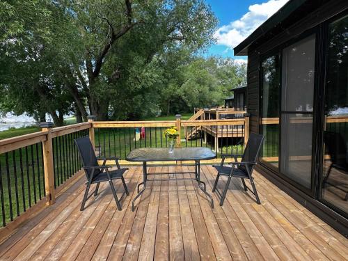 a patio with a table and chairs on a deck at 2-bedroom Lake Front Cottage in Harwood ON #1 in Harwood