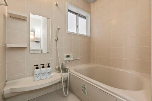 ein Badezimmer mit Badewanne und Fenster in der Unterkunft ゲストハウス奏 Private rental 136平米 5LDK Long-term stays OK in Osaka