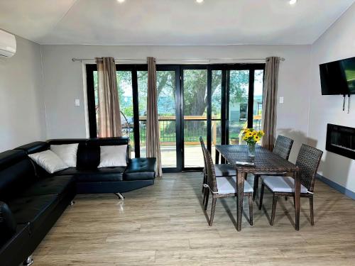 a living room with a black couch and a table at 2-bedroom Lake Front Cottage in Harwood ON #2 in Harwood