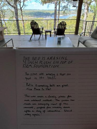 a sign for a museum with two chairs on a deck at The Lofty Cabin at Pettit Bay 