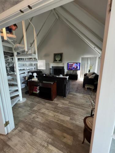 a living room with a loft with a staircase and a couch at The Lofty Cabin at Pettit Bay 