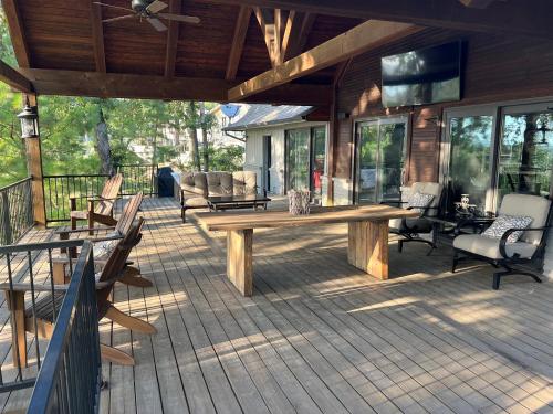 a large deck with a wooden table and chairs at The Lofty Cabin at Pettit Bay 
