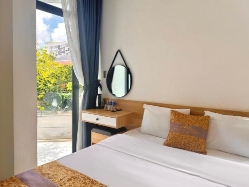 une chambre avec un lit avec un miroir et une fenêtre dans l'établissement D & A Homestay Hue, à Hue