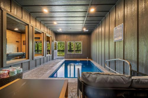 a swimming pool in a house with a couch at Modern Rooftop Mtn Views, Hot Tub, Indoor Pool, Near Dollywood & PS5 in Pigeon Forge