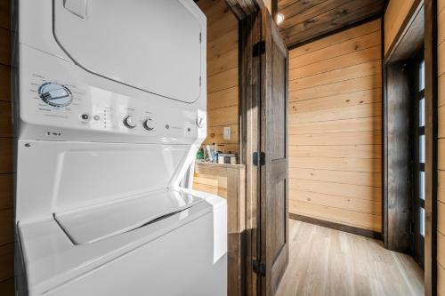a white refrigerator in a kitchen with wooden walls at Modern Rooftop Mtn Views, Hot Tub, Indoor Pool, Near Dollywood & PS5 in Pigeon Forge