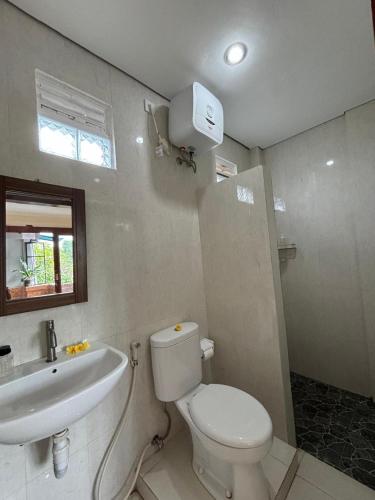 a bathroom with a white toilet and a sink at Wahadi homestay in Ubud