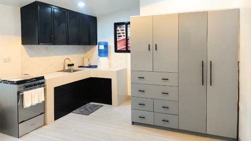a kitchen with white cabinets and a sink at Casa Margen in Ormoc