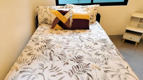 a bed with a white comforter with a yellow x on it at Casa Margen in Ormoc