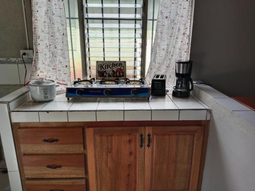 a kitchen counter with a stove in front of a window at Pacific villa lisn in Nicoya
