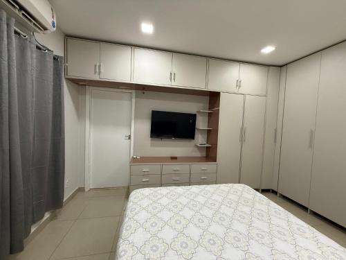 a bedroom with a bed and a flat screen tv at Casa da Anita in Boa Vista