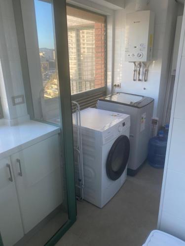 a laundry room with a washing machine and a window at Departamento en Condominio Puerto Pacífico in Viña del Mar