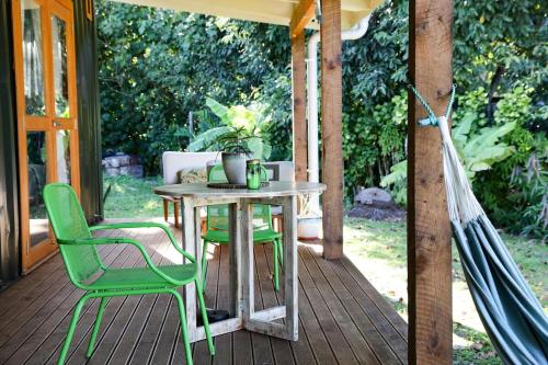 a patio with a table and chairs on a porch at Amori Cabin in Arorangi