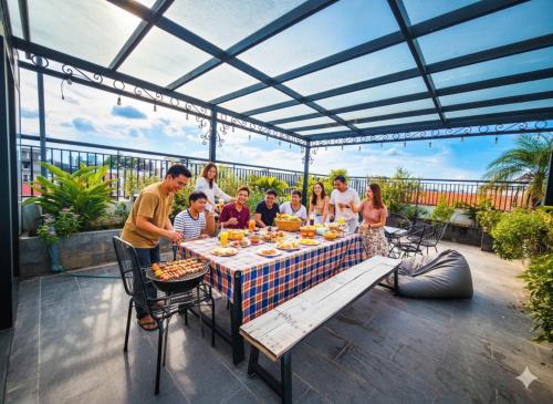a group of people sitting around a table with food at Lunaria Two Bedroom Apartment - The Epicenter of Luxury and Convenience in Hanoi