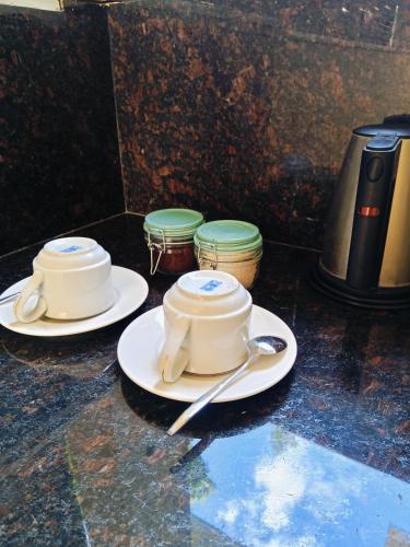 twee witte borden en een theepot op een tafel bij Soma Bloom Resort in Jembrana