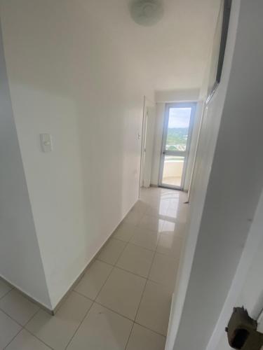 an empty hallway with a door and a tile floor at Departamento frente al mar in Tonsupa