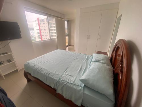 a bedroom with a bed in a room with a window at Departamento frente al mar in Tonsupa