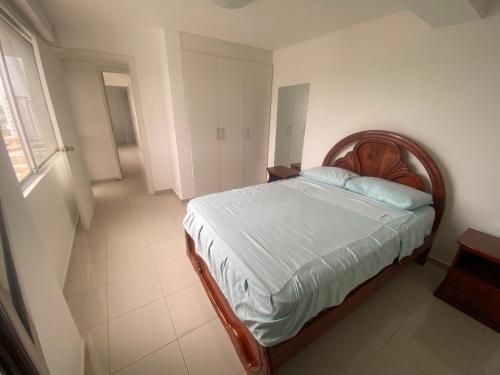 a bedroom with a bed with a wooden head board at Departamento frente al mar in Tonsupa