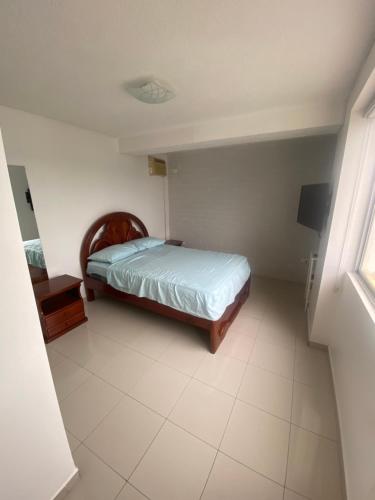 a small bedroom with a bed and a window at Departamento frente al mar in Tonsupa