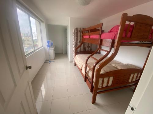 a hallway with bunk beds in a room with a window at Departamento frente al mar in Tonsupa