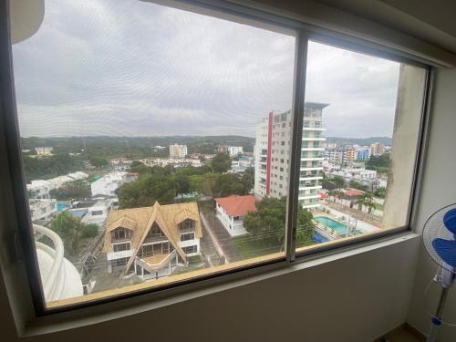 a window with a view of a city at Departamento frente al mar in Tonsupa