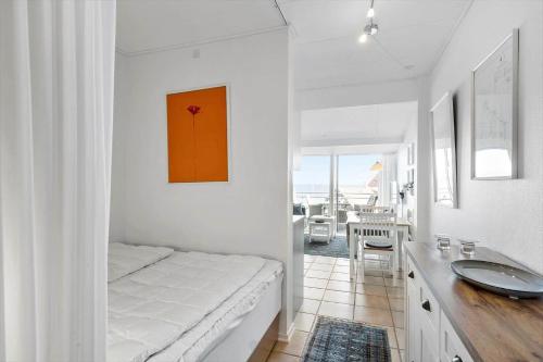 a bedroom with a bed and a sink and a table at 5579-Gudhjem-Sdr-Strandvej-128-1-lejl-17 in Gudhjem