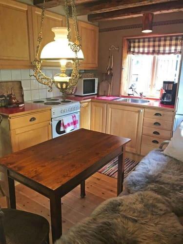 a kitchen with a wooden table and a kitchen with a stove at VGO674-Kalv-Yttre-Backa-4 in Svanabo