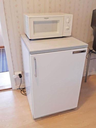 a microwave sitting on top of a white refrigerator at DAL768-Amal-Orgelvaegen-13 in Åmål