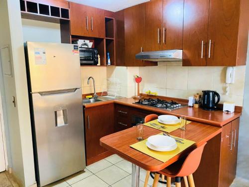 a kitchen with a refrigerator and a table with plates on it at Disfruta Departamento-1Hab-1Baño in Antofagasta