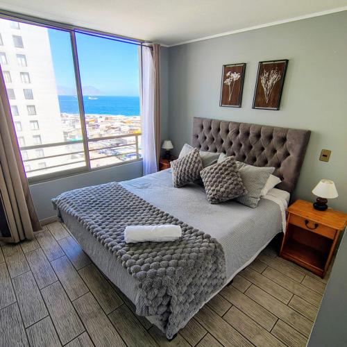 a bedroom with a bed with a view of the ocean at Experiencia 2Terramar 1Hab-1Baño-1 Estac in Antofagasta
