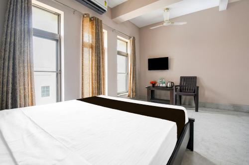 a bedroom with a bed and a chair and a window at Hotel O Aasiyanaa Guest House in Bhubaneshwar