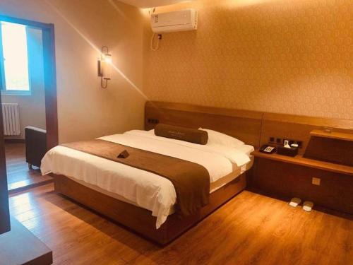 a bedroom with a large bed in a room at James Joyce Coffetel Qufu Tourist Center Gulou Street Sankong Scenic Spot in Jining