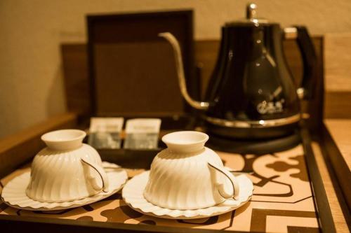 two white cups and saucers sitting on a table at James Joyce Coffetel Qufu Tourist Center Gulou Street Sankong Scenic Spot in Jining