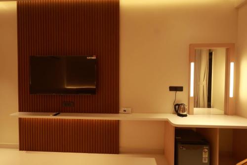 a hotel room with a tv on a wall at FRESH UP HOTEl in Tirupati
