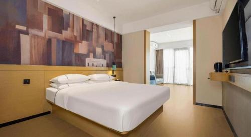 a large white bed in a room with a tv at City Comfort Inn Liuzhou Wuling Liutai Road in Liuzhou
