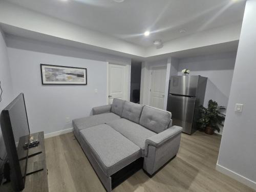 a living room with a couch and a refrigerator at Peaceful Haven in Prime Location in Calgary