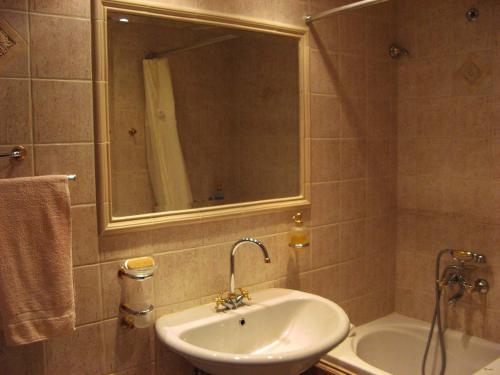 a bathroom with a sink and a mirror and a tub at Apartment Alea in Portorož