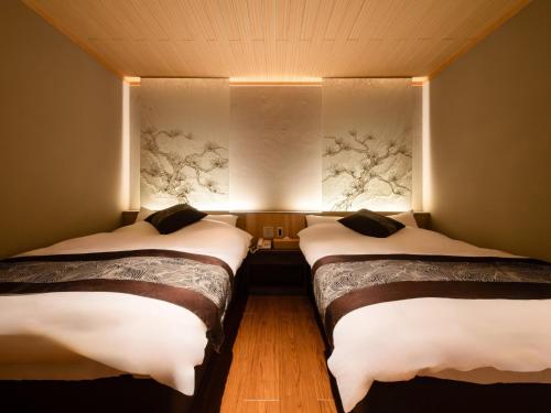 two beds in a room with lights on the wall at Haiya in Awara