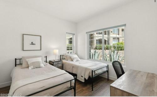 ein weißes Zimmer mit zwei Betten und einem Fenster in der Unterkunft Catalina Location Peaceful Near Parks in Oro Valley