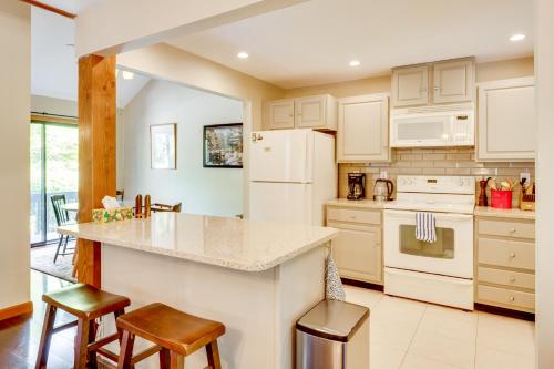 a kitchen with white appliances and a counter with stools at Near Skiing and Hiking! North Conway Gem with Balcony in Intervale