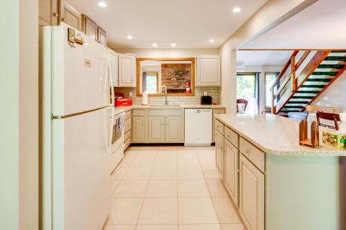 a kitchen with white appliances and a staircase at Near Skiing and Hiking! North Conway Gem with Balcony in Intervale