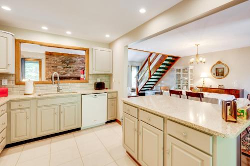 a kitchen with white cabinets and a staircase at Near Skiing and Hiking! North Conway Gem with Balcony in Intervale