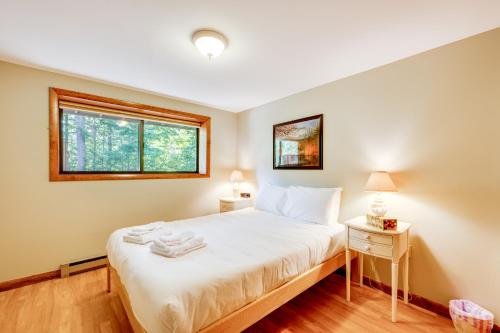 a bedroom with a bed with white sheets and a window at Near Skiing and Hiking! North Conway Gem with Balcony in Intervale