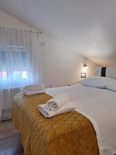 une chambre avec un grand lit avec des serviettes dessus dans l'établissement Apartmani Lu, à Zadar